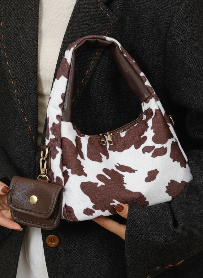 petit sac a main avec petite sacoche style tache animal marron fonce portee style femme elegante tenu par la main