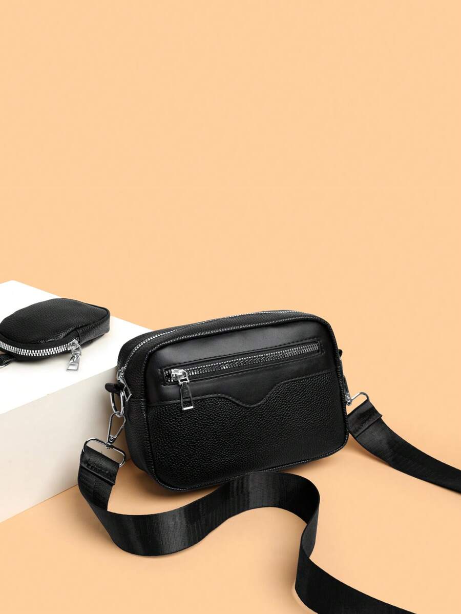 sacoche noir uni posee sur sol avec mini sacoche sur sangle ovu de devant poseeuverture fermeture eclair contenance